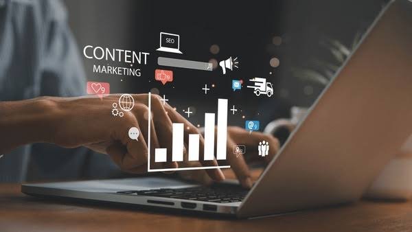 A marketer working on a laptop with analytics charts, illustrating content marketing, audience engagement, and digital growth strategies.
